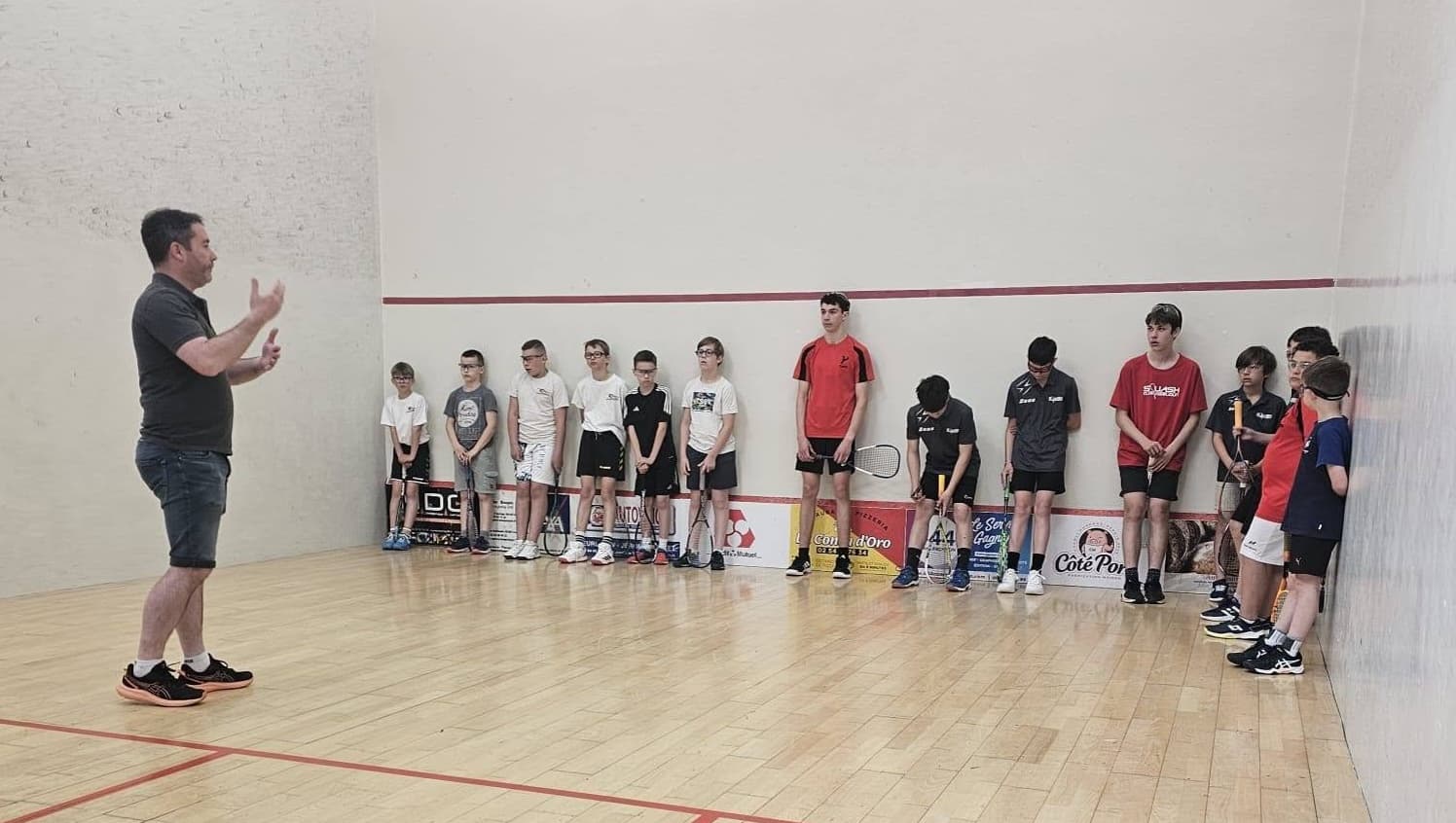 Les jeunes du club à l’écoute de leur éducateur sur le court