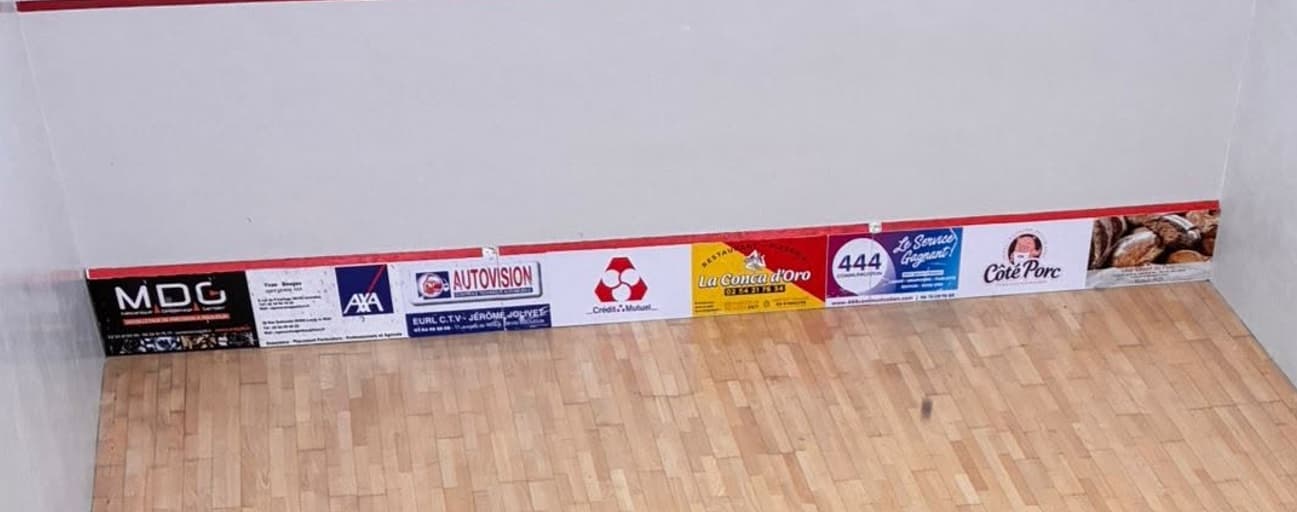 Le tin d’un court, habillé des logos des partenaires du club